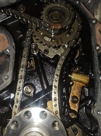 Close-up of an engine timing chain and gears inside a GDL Auto repair bay